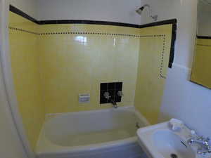 Apt # 8 > Bathroom featuring tile walls and washtub / shower combination