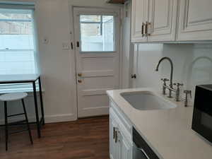 Apt # 16 > Laundry room featuring a sink and dark wood-type flooring