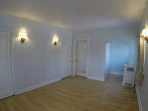 Apt # 15 > Spare room with light wood finished floors and arched walkways