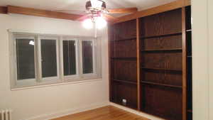 Apt # 12 > Spare room featuring light wood-type flooring, a ceiling fan, and radiator heating unit