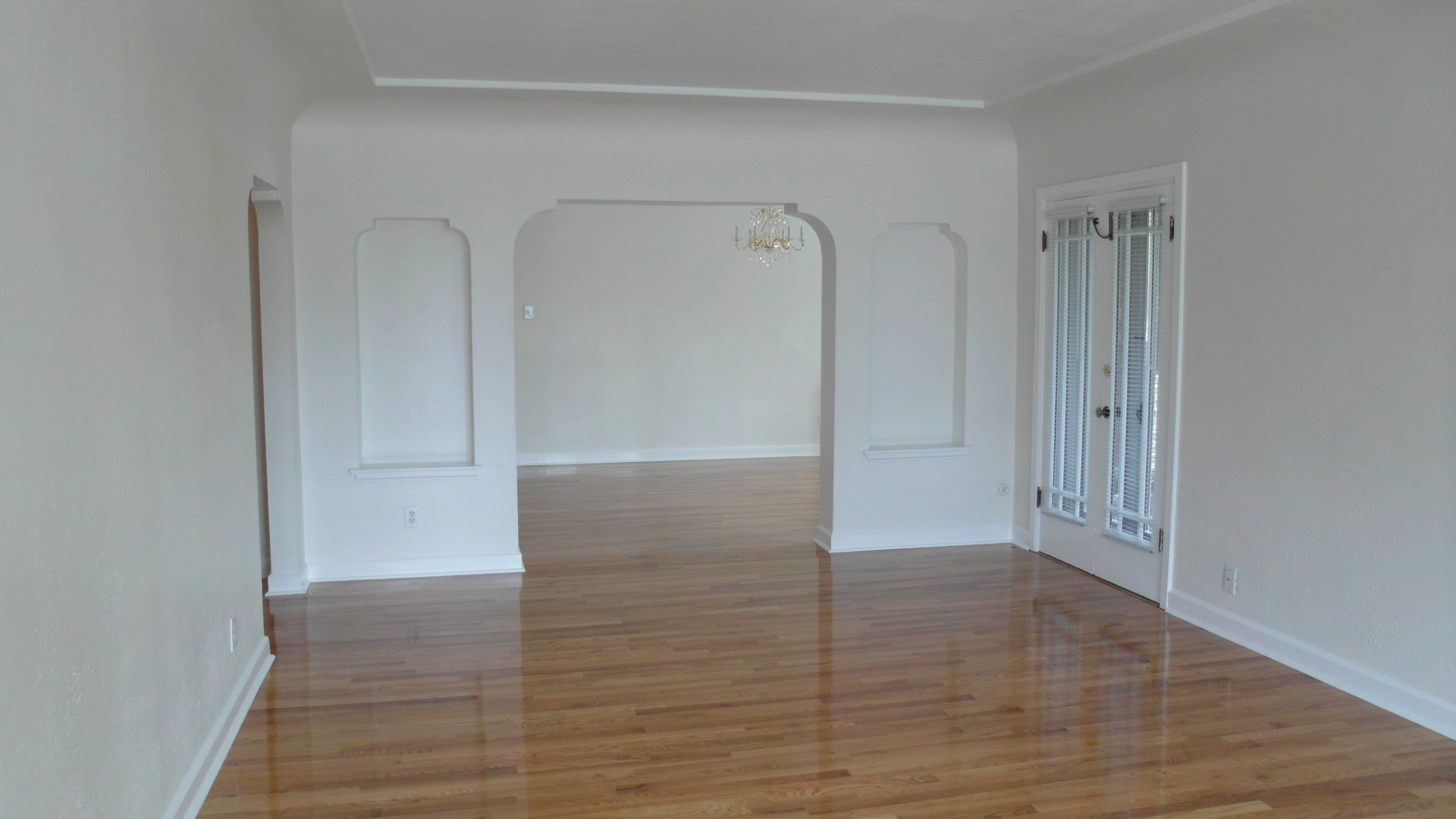 Apt # 10 > Spare room featuring a chandelier and light wood-style floors