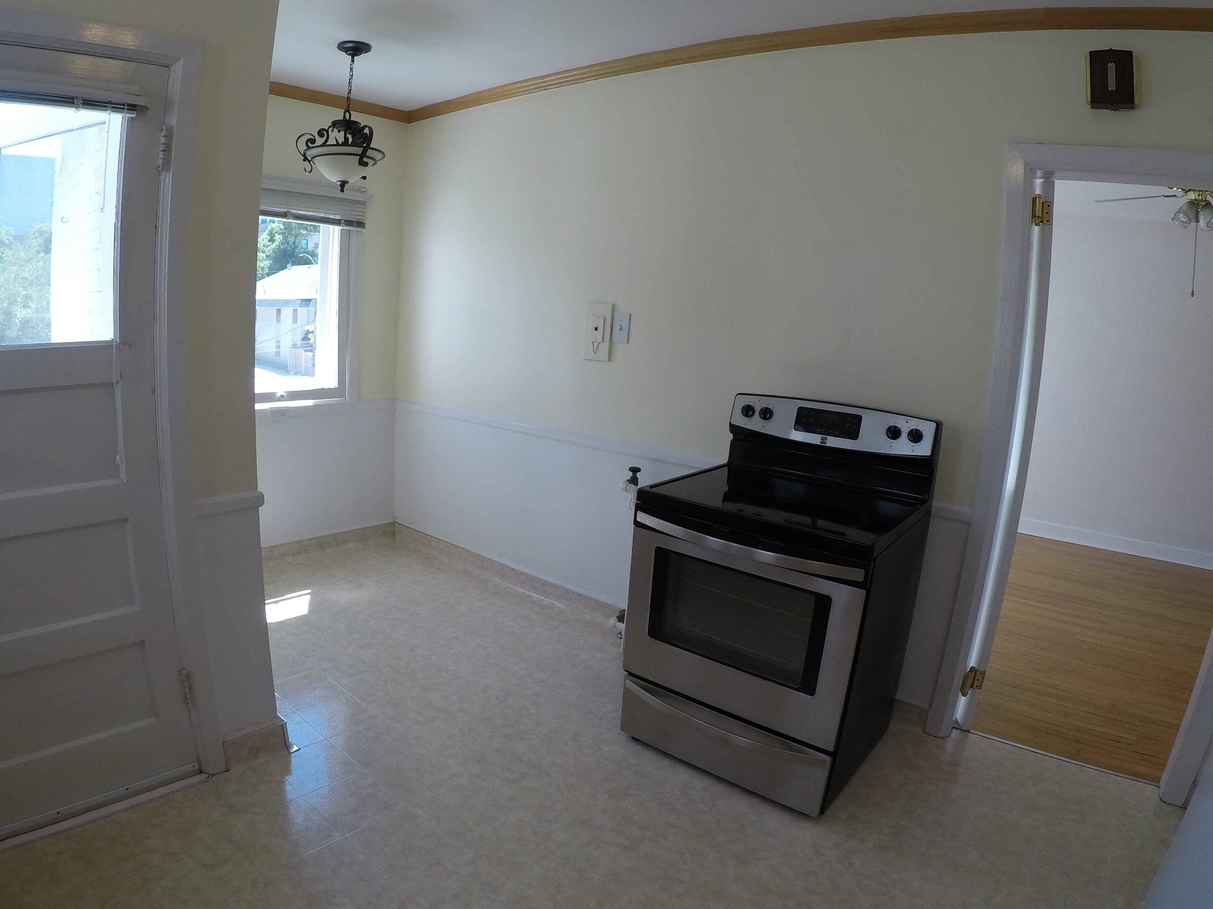 Apt # 8 > Kitchen with stainless steel range with electric cooktop, crown molding, light floors, and ceiling fan