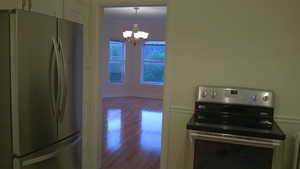 Apt # 7 > Kitchen featuring stainless steel appliances, a chandelier, dark wood finished floors, and pendant lighting