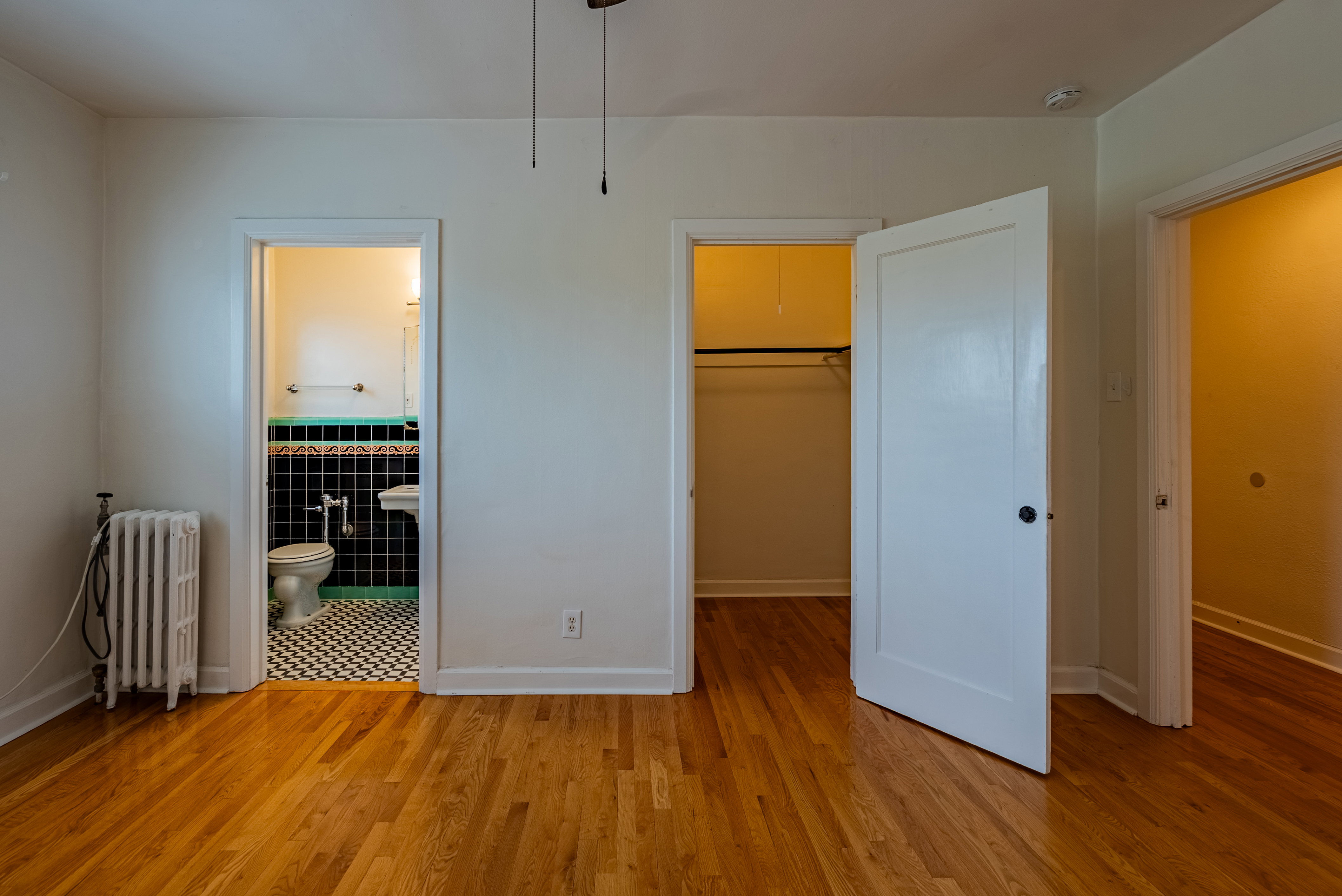 Hardwood flooring extends throughout the room, complemented by white painted walls and trim
