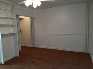 Apt # 16 > Unfurnished bedroom with dark colored carpet, ceiling fan, and a closet