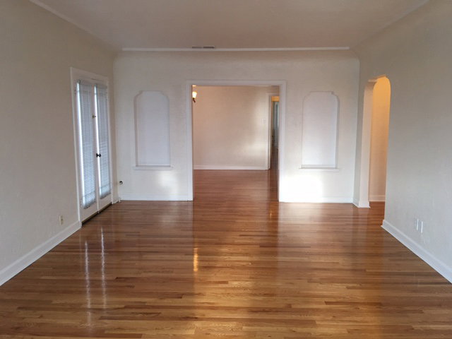 Apt # 7 > Spare room with arched walkways and wood finished floors