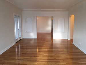 Apt # 7 > Spare room with arched walkways and wood finished floors
