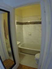 Apt # 7 > Full bathroom featuring toilet and wood finished floors