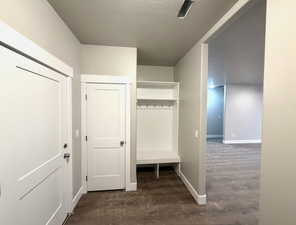 Mudroom with baseboards and a textured ceiling
