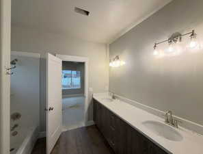 Bathroom featuring double vanity and dark wood-style floors