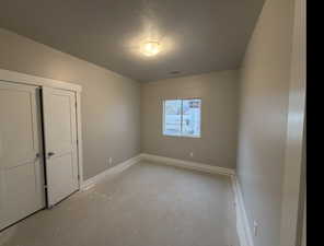 Unfurnished bedroom with concrete flooring and a textured ceiling
