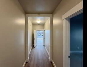 Hall with baseboards and dark wood-type flooring