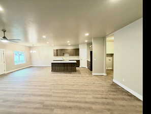 Unfurnished living room with recessed lighting, light wood-style floors, and a chandelier
