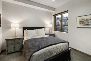 Bedroom with baseboards and dark colored carpet