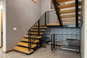 Stairway featuring baseboards and finished concrete flooring