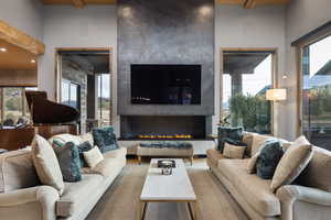 Living room with a fireplace, healthy amount of natural light, and a wood ceiling with exposed beams