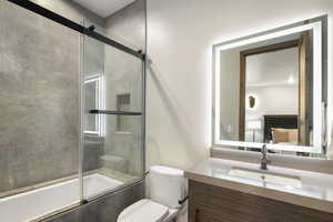Bathroom featuring enclosed tub / shower combo and vanity