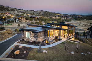 View of front of house featuring a patio, asphalt driveway, and stone siding