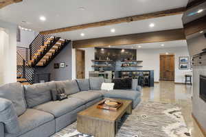 Living room with stairs, wet bar, beamed ceiling, and recessed lighting