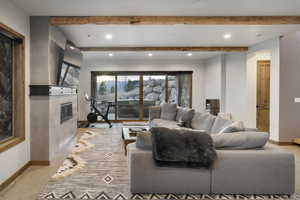 Living area with a fireplace, beam ceiling, and recessed lighting