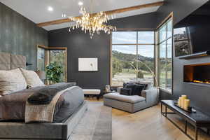 Bedroom featuring wood finished floors, a chandelier, recessed lighting, and a fireplace
