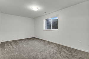 Carpeted spare room with baseboards
