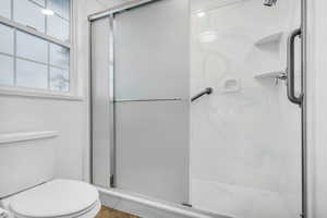 Bathroom with a marble finish shower and toilet