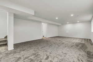 Finished basement with stairway, light carpet, and recessed lighting