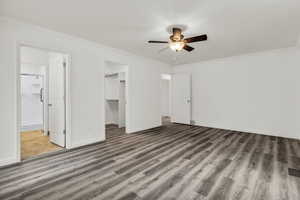 Unfurnished bedroom with ornamental molding, a walk in closet, a ceiling fan, light wood-style flooring, and ensuite bathroom
