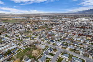 Aerial view of property and surrounding area featuring nearby suburban area and a mountain backdrop