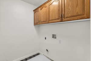 Washroom featuring wood finished floors, washer hookup, and cabinet space