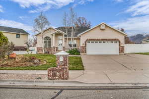 View of front facade featuring brick siding, concrete driveway, an attached garage, and a shingled roof