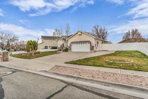 View of front of home featuring concrete driveway, brick siding, a gate, and an attached garage