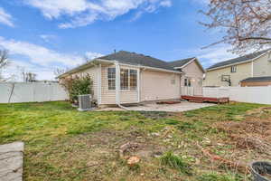 Back of house featuring a fenced backyard, a deck, and a patio
