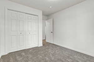 Unfurnished bedroom featuring carpet flooring and a closet