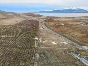 Aerial view of property and surrounding area featuring rural landscape, a mountainous background, and abundant farmland