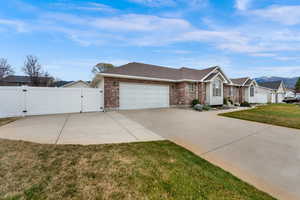 Ramblrt-style house with a gate to RV parking and 2 car detached shop/garage, and 2 car attached garage
