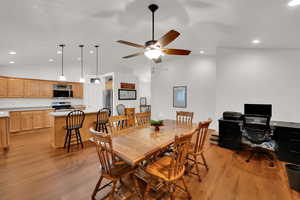Dining area with LVP floors, recessed lighting, ceiling fan, and high vaulted ceiling