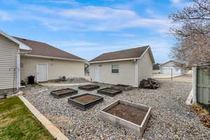 Rear view of house shop/garage, and a raised garden boxes.