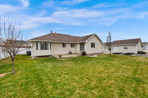Back of house featuring a patio area, a lawn, and entry steps