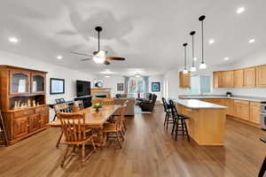 Dining space featuring recessed lighting, a tile fireplace, LVP floors, vaulted ceiling, and a ceiling fan