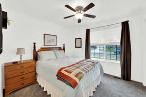 Bedroom featuring a ceiling fan, crown molding, and new carpet
