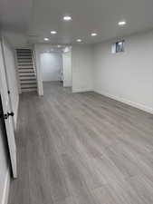 Finished basement with stairway, recessed lighting, and light wood finished floors
