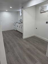 Bar area featuring electric range, white cabinets, wood tiled floors, light countertops, and recessed lighting