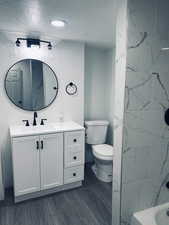Bathroom with vanity, a bathtub, a marble finish shower, and recessed lighting