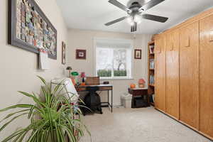 Office area with light colored carpet and a ceiling fan