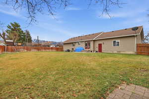Back of property featuring a patio area, a fenced backyard, roof with shingles, and entry steps