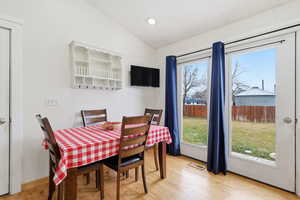 Dining area featuring vaulted ceiling, light wood-type flooring, and recessed lighting