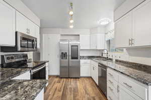 Kitchen with updated white cabinets, granite countertops, stainless appliances, and new above sink lighting