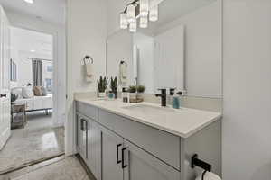 Full bathroom featuring double vanity, light colored carpet, and connected bathroom